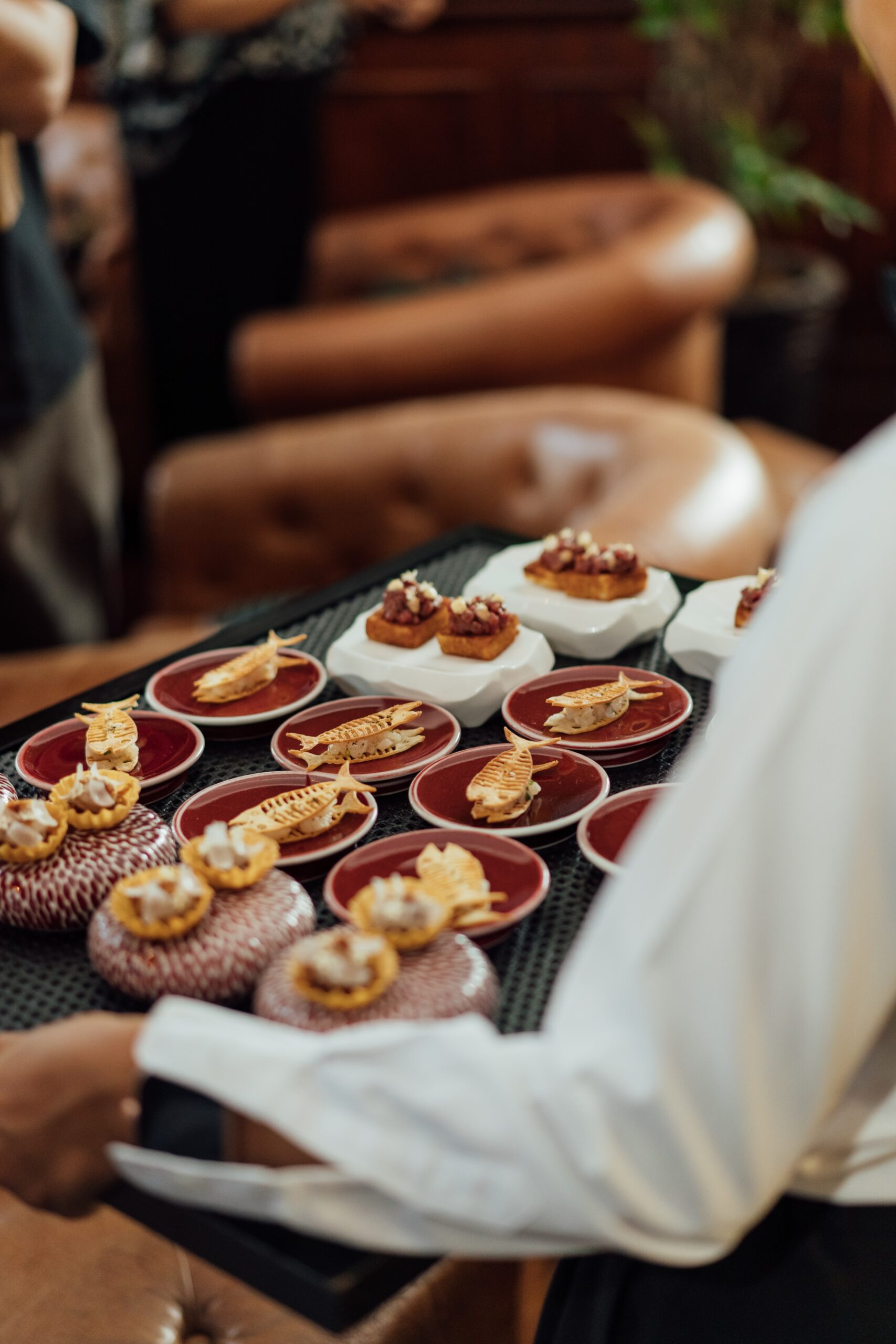 A caterer holding a tray of canapés